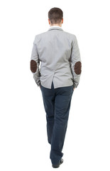 Fototapeta premium Back view of walking businessman. Rear view people collection. Backside view of person. Isolated over white background. The bearded man in a gray jacket, talking with his hands in his pocket.