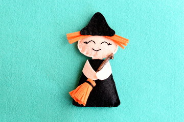 Halloween witch doll isolated on a blue felt background. Homemade cute witch crafts idea for kids....