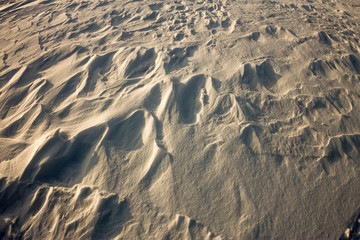background snow waves at sunset by the wind