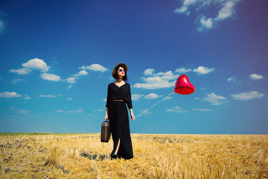 young woman with suitcase and balloon
