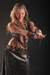 young girl in beads and bracelets on black background