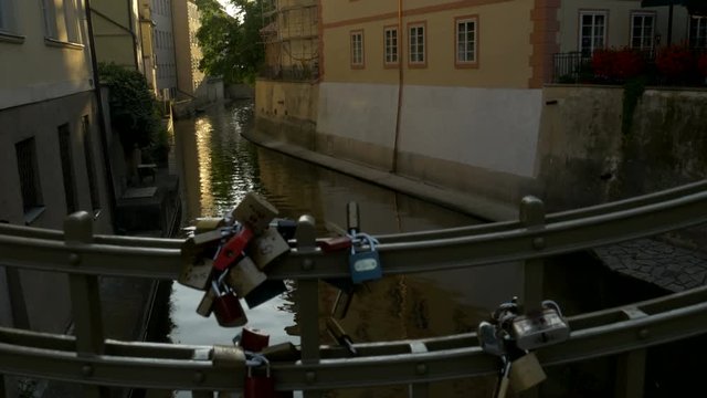 Tilt up from love locks on railings below the Charles Bridge in Prague. Taken from Certovka 