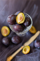 plums on a dark background in a glass vase clay blue summer berry fruits