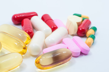 Pills and capsules on white background