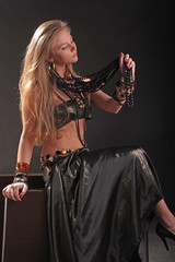 young girl in beads and bracelets on black background