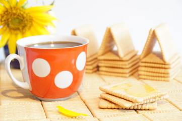 Sponge cake with honey. House crackers. Still crackers and a cup of black coffee. Red cup with white polka dots.