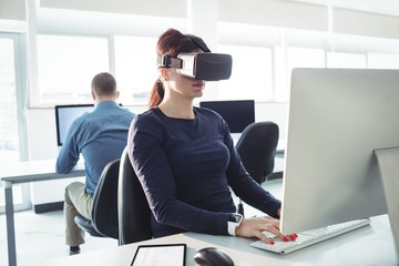 Mature student in virtual reality headset using computer