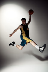 Fototapeta na wymiar Full length portrait of a basketball player with ball