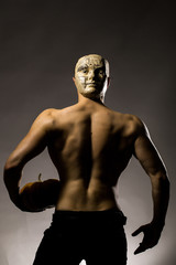 Fototapeta na wymiar muscular man in mask with pumpkin