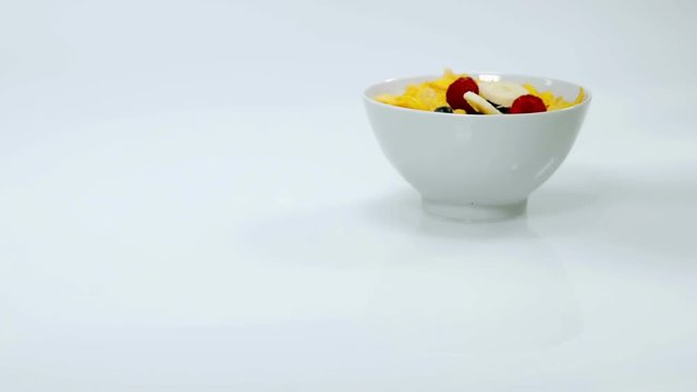 Different druits and corn flakes are standing in the cup together. The meals looks very nice and someone will have it for his breakfast. Close-up shot.

