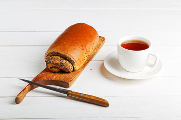Roll with poppy seeds and cup of tea
