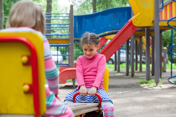Fototapeta na wymiar funny girls riding on swing at playground.