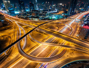 Fototapeta premium Niezwykła arteria prowadząca do Abu Zabi w godzinach szczytu nocnego w pobliżu największych drapaczy chmur. Korek z wieloma samochodami. Dubaj, Zjednoczone Emiraty Arabskie.