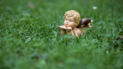 Engel Figur im Gras als Hintergrund oder Karte für Trauer, Tod oder Kondolenz und Schutzengel