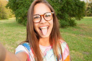 Close up portrait of a young attractive woman holding a smartphone and taking a selfie