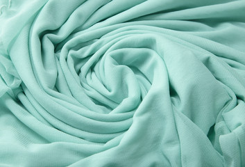 A full page close up of a swirl of green chiffon fabric texture