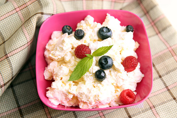 Cottage cheese in pink plastic bowl decorated mint and berry.