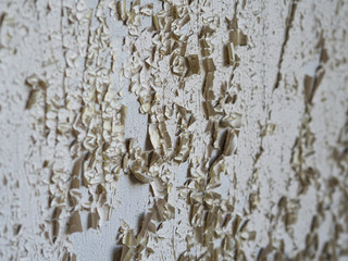 Abgeblätterte beige Farbe an einer Wand