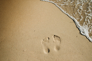 Two footprints on the beach in the sand
