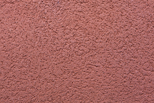 Burgundy red painted stucco wall. Background texture
