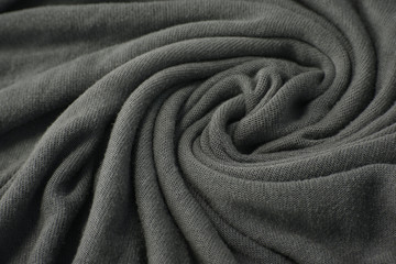 A full page close up of a swirl of grey fine knit sweater fabric texture