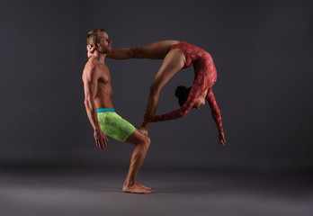 Couple of acrobats performing trick in studio