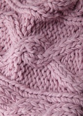 A full page close up of pink cable knit sweater fabric texture