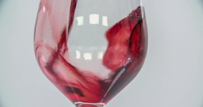 Someone is pouring a delicious red wine into a clean glass and he will enjoy it for his dinner. Close-up shot.
