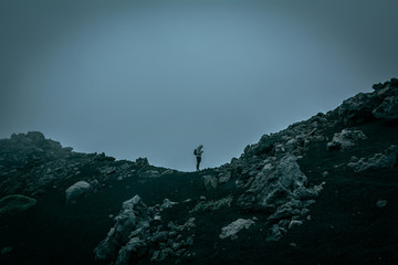 Fototapeta premium A human figure in a volcanic landscape in a foggy day
