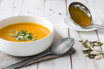 Pumpkin soup in bowl on a white wooden table

