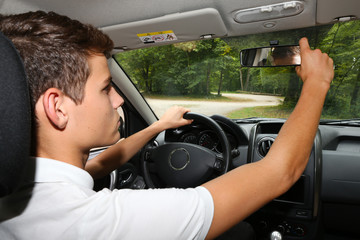 Man adjusting his mirror in a car