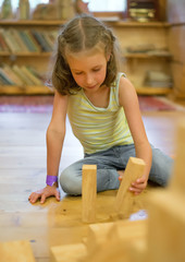 Little girl playing with wooden blocks.