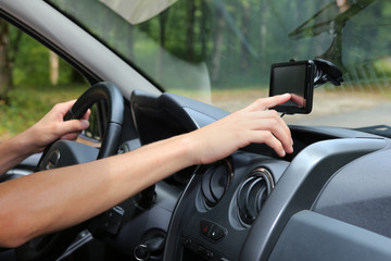 Obraz na płótnie Canvas Man adjusting his GPS in a car