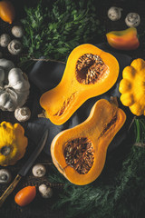 Pumpkin with different vegetables on the old wooden table vertical