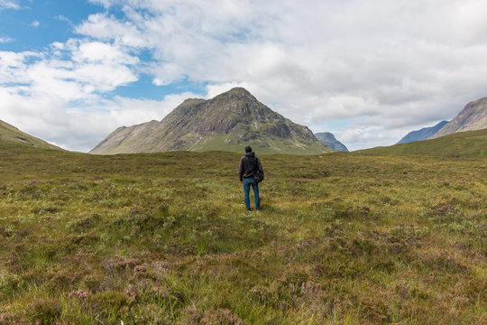 Junger Mann blickt in die Landschaft, Highlands, Schottland, Rückenansicht, 