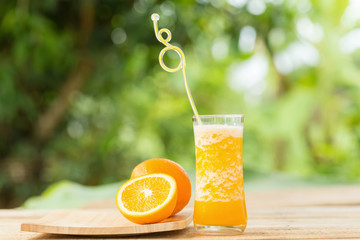 Glass of Orange Smoothie on garden background