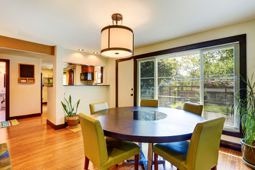 Nice dining area with round table and green chairs.