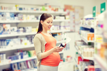 happy pregnant woman with medication at pharmacy