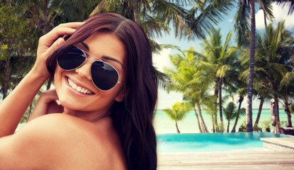 smiling young woman with sunglasses on beach