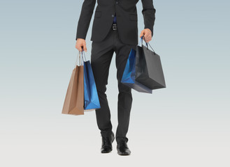 close up of man in suit with shopping bags