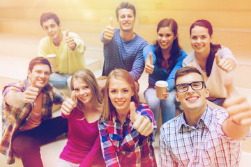 group of smiling students with paper coffee cups