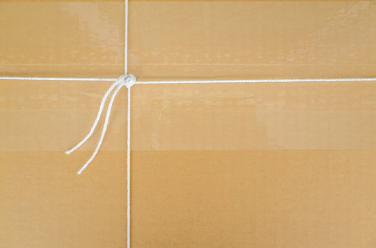 white string tied on brown corrugated box with space