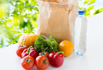 close up of paper bag with vegetables and water