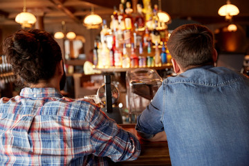 close up of male friends at bar counter in pub