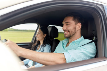 happy man and woman driving in car