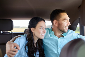 happy man and woman hugging in car