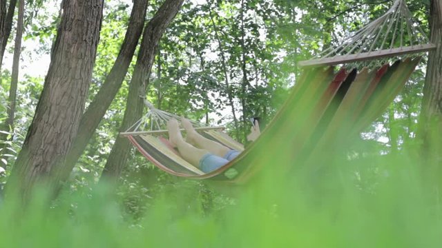 Young woman lying in a hammock in garden