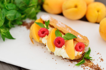 choux pastry with raspberry and apricot. Modern supply of gold a