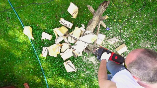 Elderly man using chainsaw