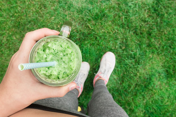 Young girl drinking fruit smoothie . Fitness and healthy lifestyle concept.
